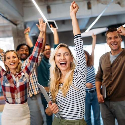 Happy business people celebrating success at company office